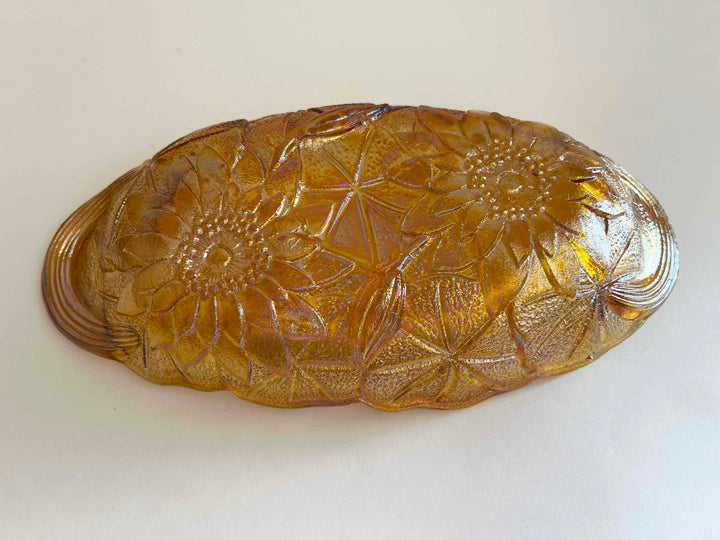 Look of the raised edges in the lily pattern on a vintage gold glass pickle dish.