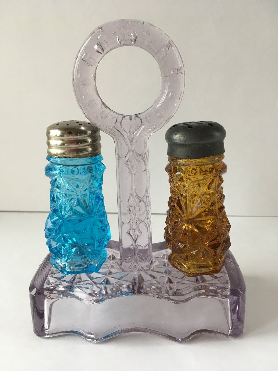 Set of Daisy and Button pattern salt and pepper shakers with loop handled holder.