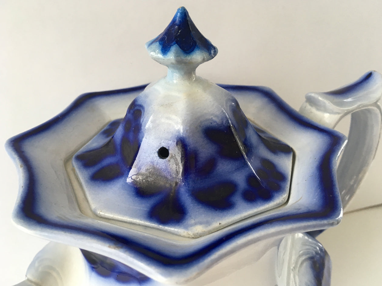 Close-up of lid of flow blue ironstone teapot in Blueberry pattern.