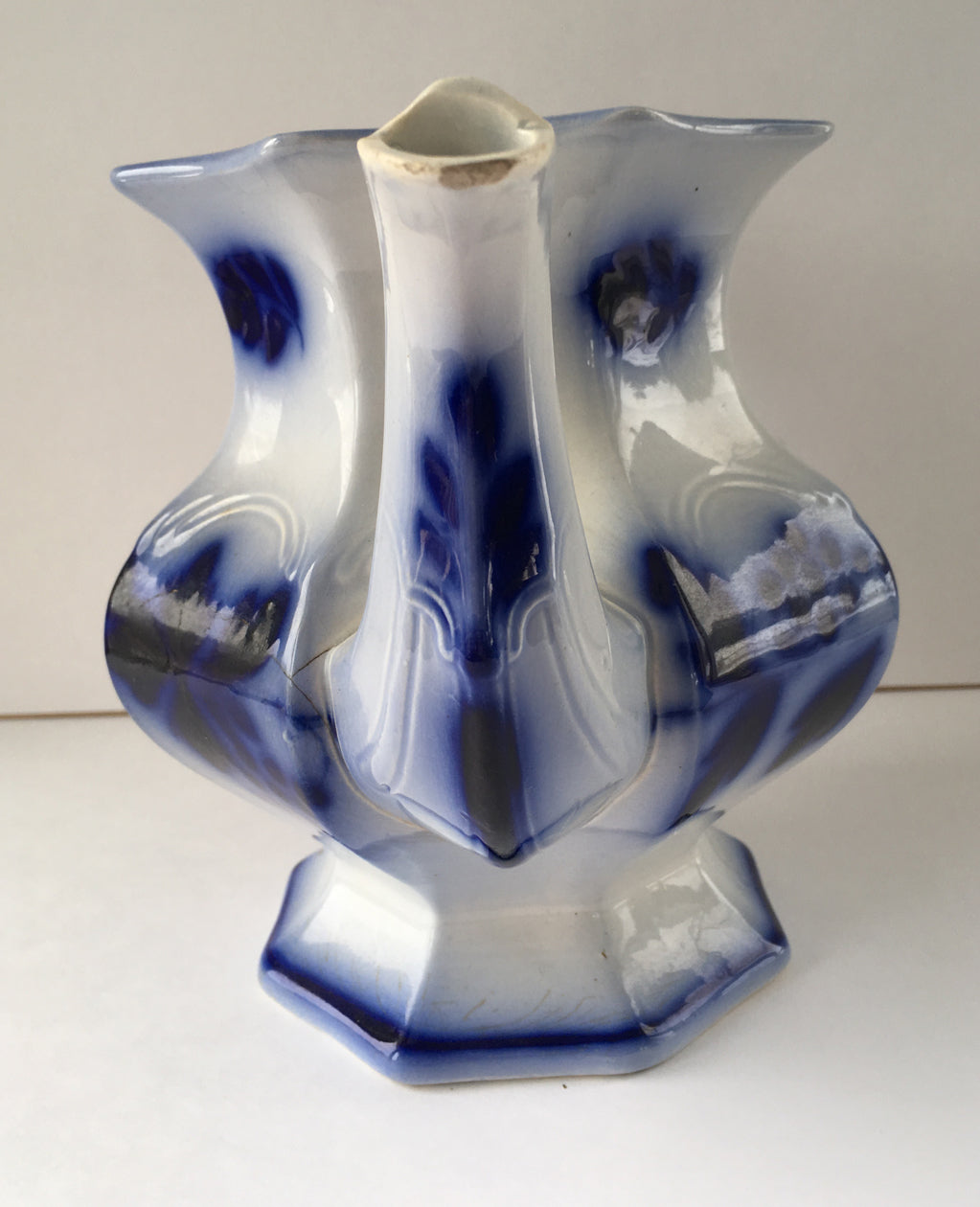 Close-up of spout of flow blue ironstone teapot in Blueberry pattern.