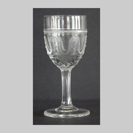 Antique clear glass cordial with cord and tassel pattern on the sides.