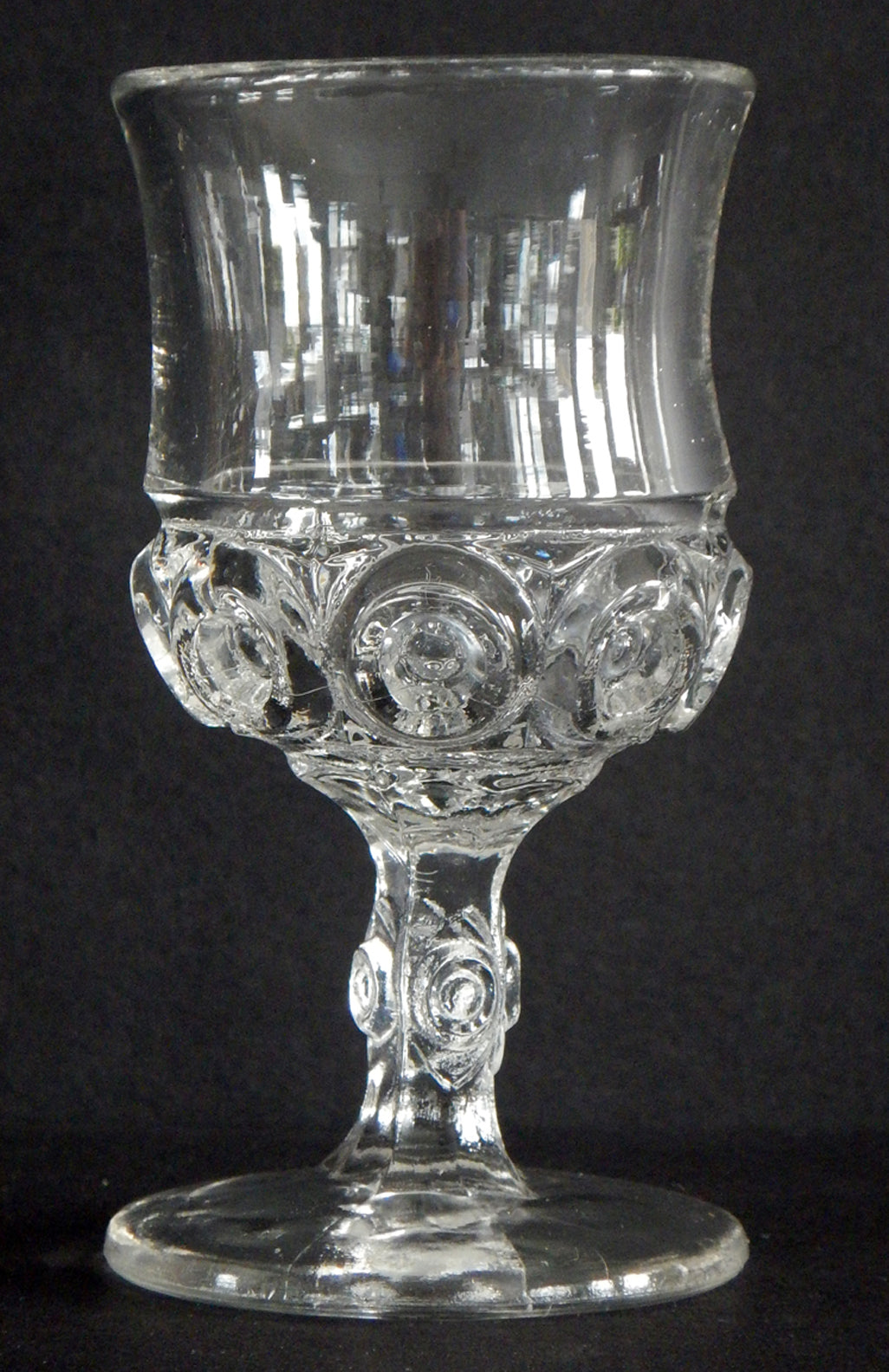 Close-up of antique glass cordial, Sunken Bullseye pattern in the cup and stem.