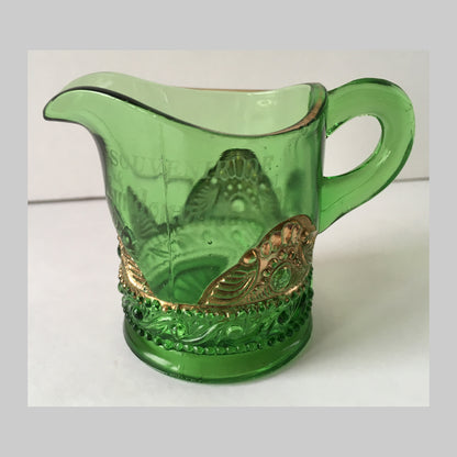 Antique green pressed glass creamer with gold bejewelled scallops around the base.