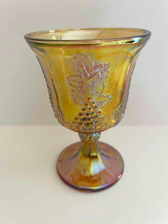 This is an Iridescent Gold Carnival Glass Goblet.  It is the Harvest Pattern and the maker is Indiana Glass, circa 1972-73.