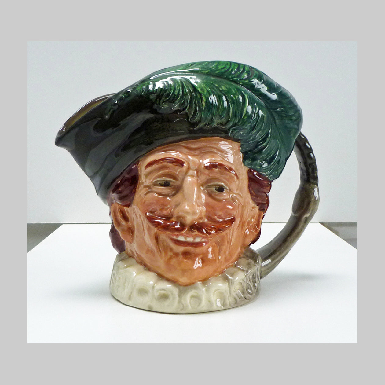 Royal Doulton large character jug with handle of a green capped Cavalier figure. 