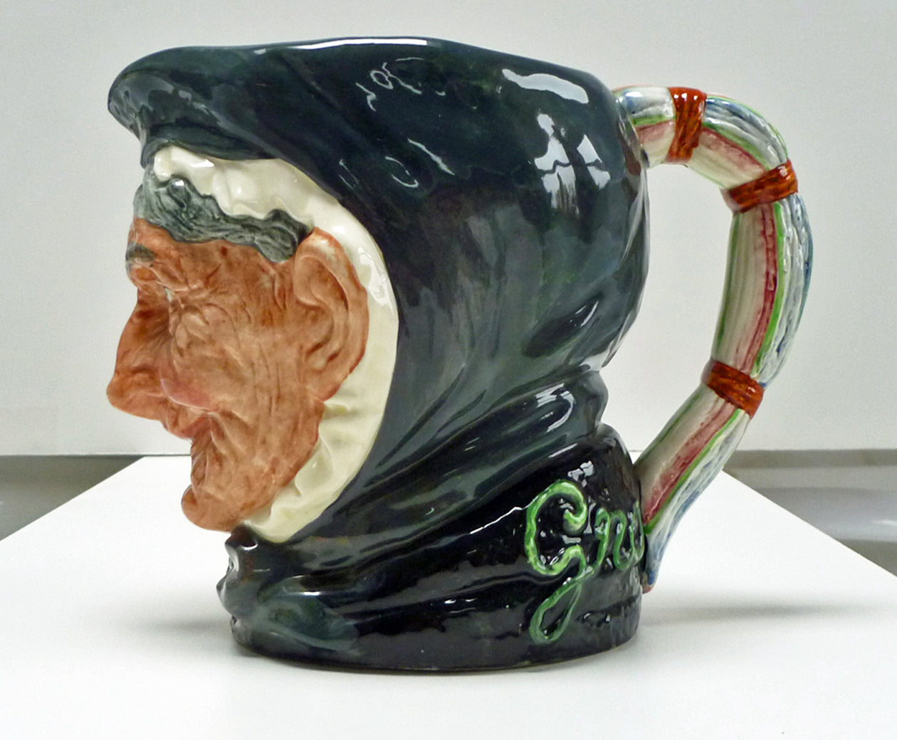 Left side of a large Royal Doulton single toothed Granny jug. 