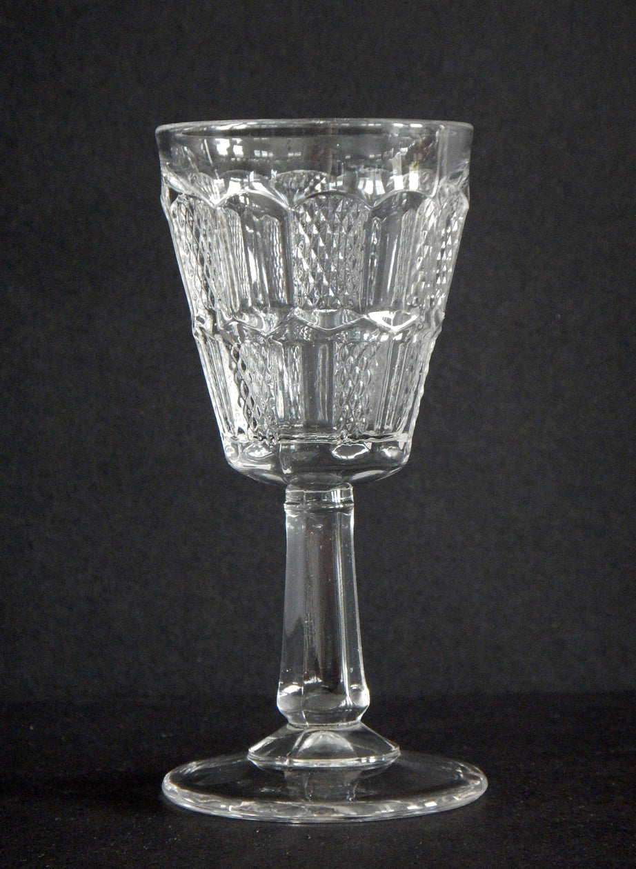 Close-up of checker board design on pressed glass Hand pattern cordial.