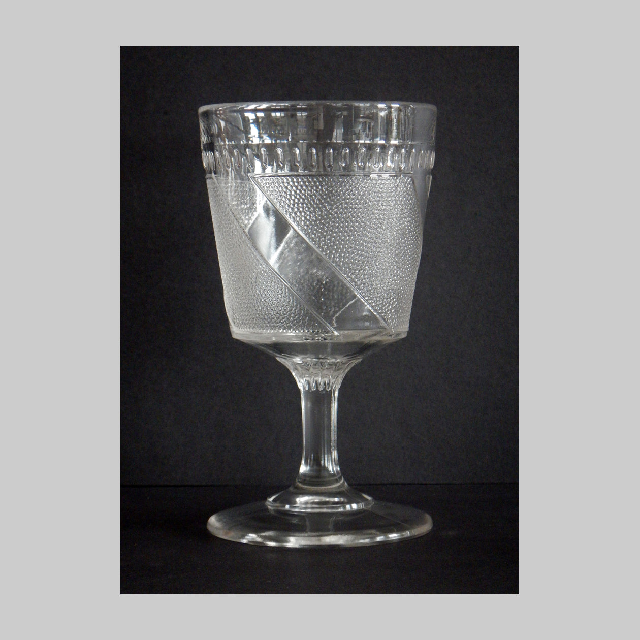 Antique clear pressed glass goblet in Clear Diagonal Band pattern.