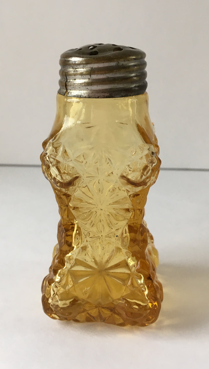 Amber coloured antique glass shaker with a lid with a flat lid. 