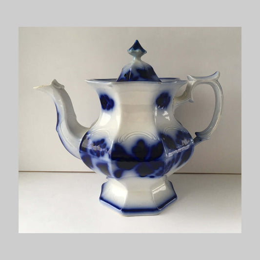 Antique flow blue ironstone teapot in Blueberry pattern in blue and white.