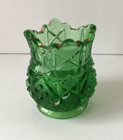 Close-up of glass toothpick holder with scalloped edges in Sunbeam pattern.